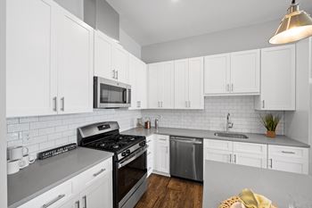 a kitchen with white cabinets and stainless steel appliances